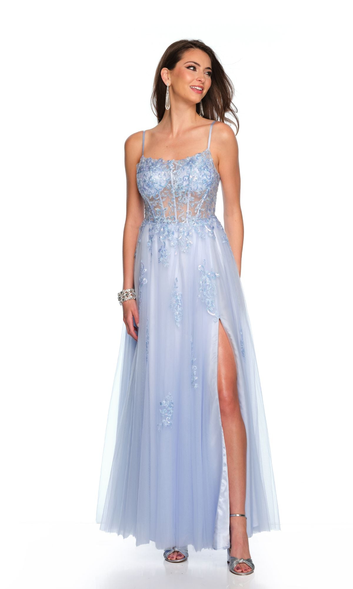 A woman stands against a white background wearing the Long Formal Dress 11614 by Dave and Johnny—a pastel sky blue tulle A-line gown with floral embroidery, sheer sweetheart bodice, and a high slit.